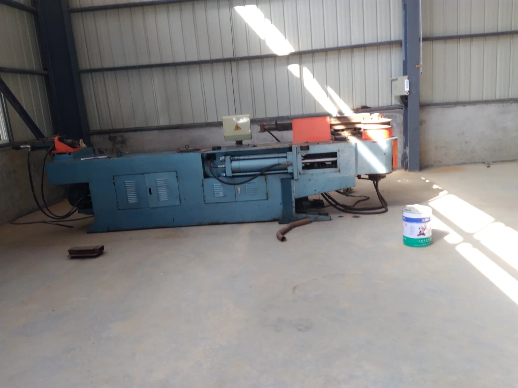 Metal bending equipment positioned inside a factory workshop