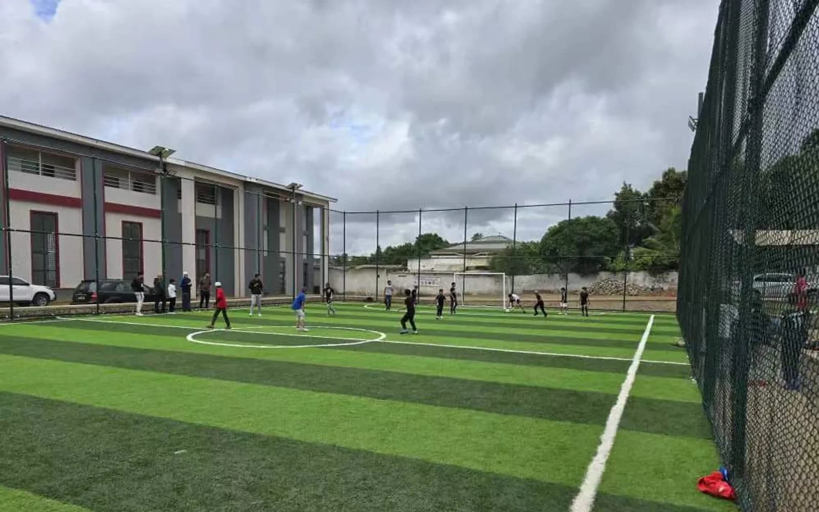 Players using the completed small-sided football pitch in Malawi
