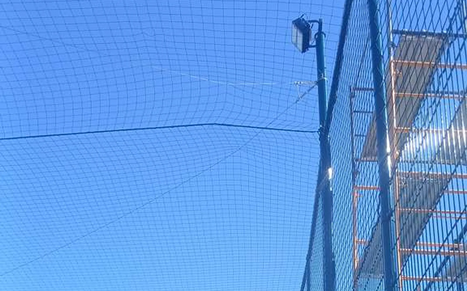 Overhead net containment and perimeter mesh at the United States football facility